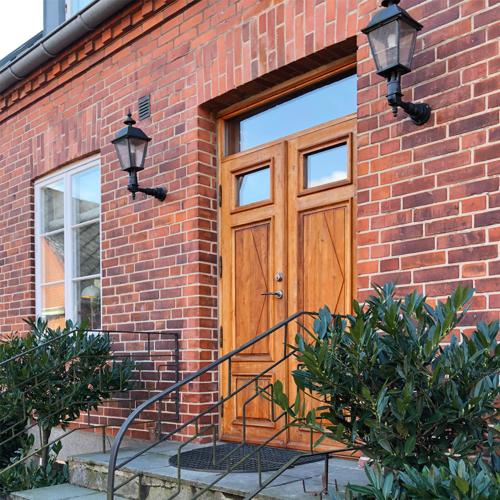 pardörrar i teak på ett tegelhus